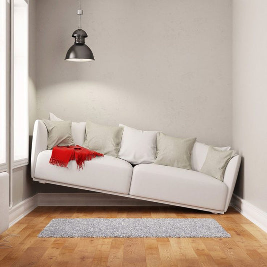 Modern white sofa with cushions and red throw in a minimal living room highlighting the cost of poorly designed living spaces