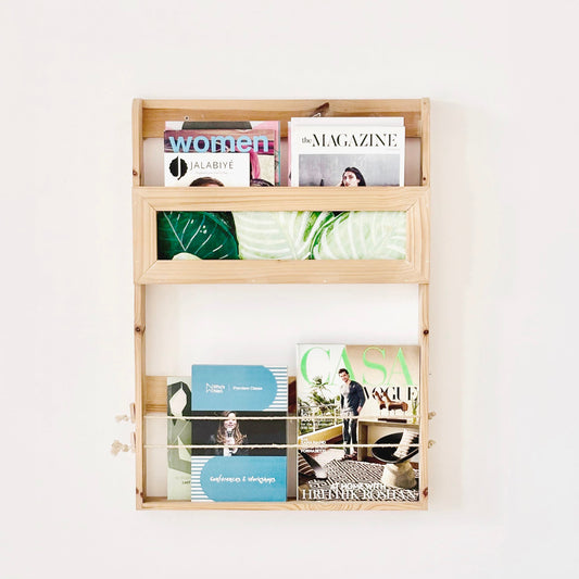 Natural wood minimalist magazine rack loaded with magazines showing functional storage design