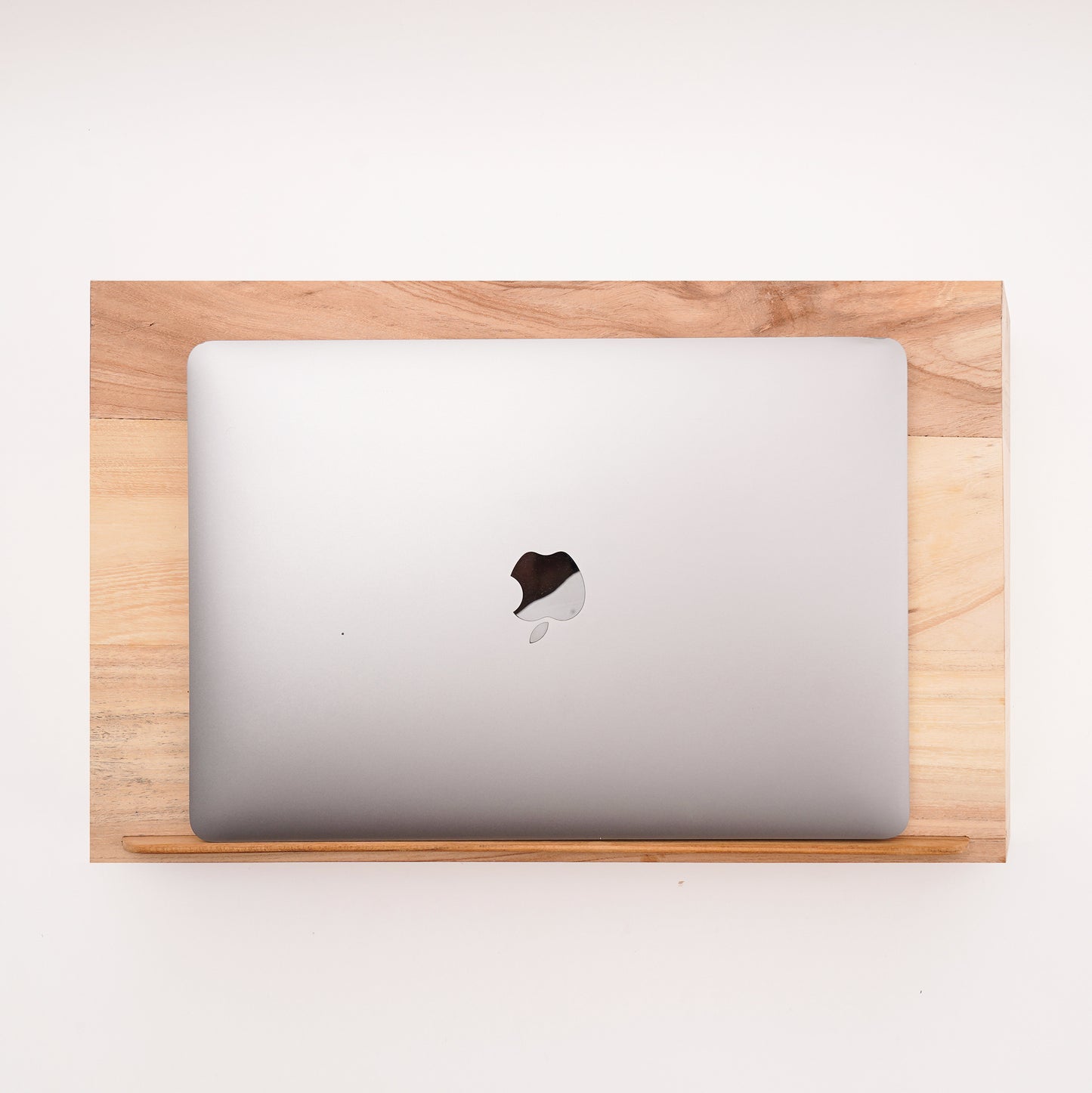 A Good Life laptop stand made of pinewood ergonomic work desk with a closed silver laptop on top