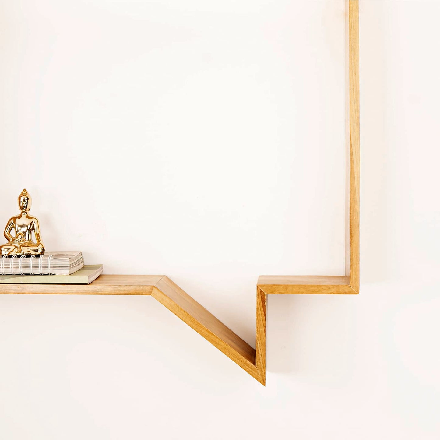 Minimalist Wabi-Sabi quote display shelf by A Good Life with wooden geometric design holding books and a gold statue