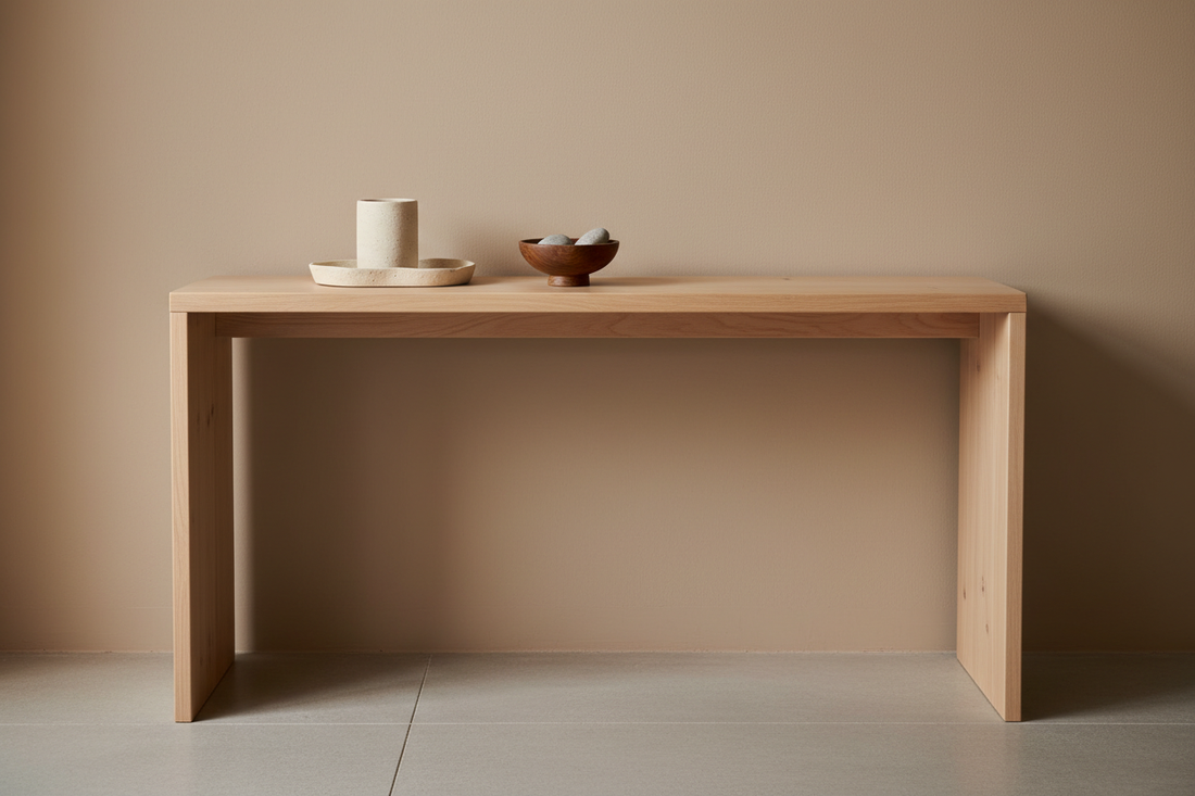 A light matte pinewood console table with a ceramic tray, tissue holder and small wooden bowl arranged with intention in a calm neutral interior