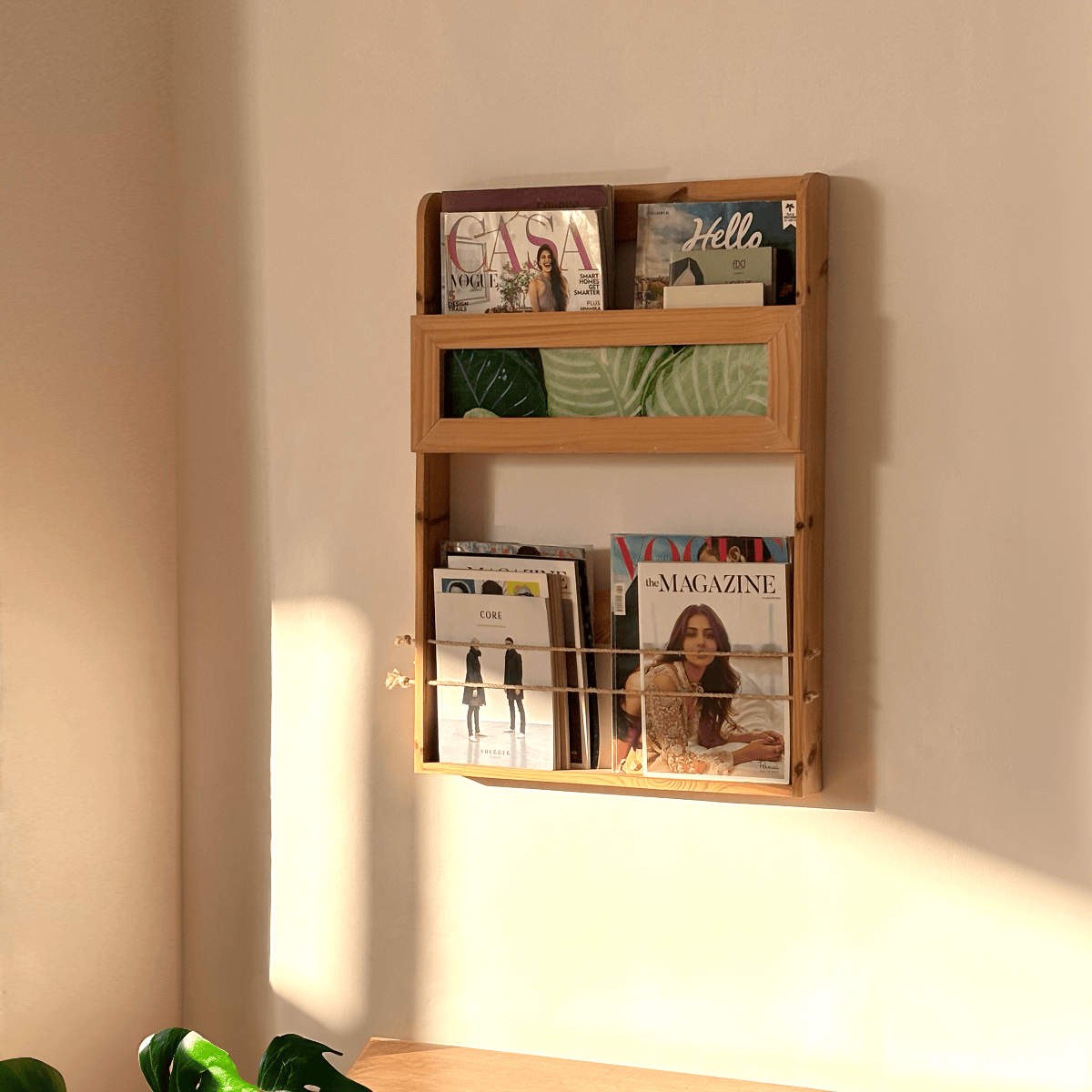 Pine wood minimalist magazine rack in warm light loaded with journals for cozy reading nook ambiance