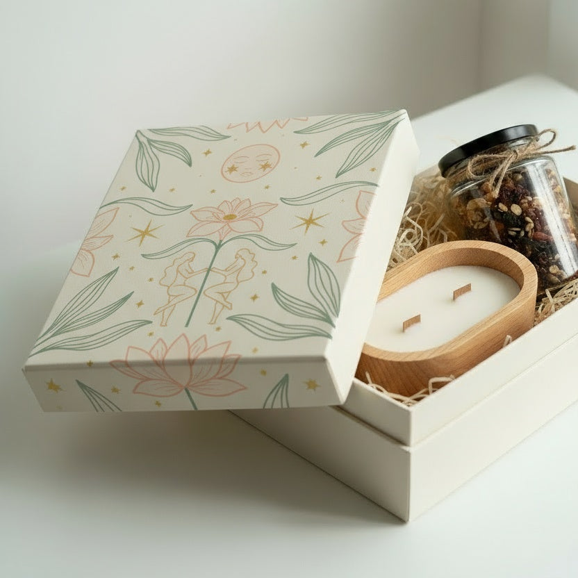 Gift box with a candle and other items on a white surface