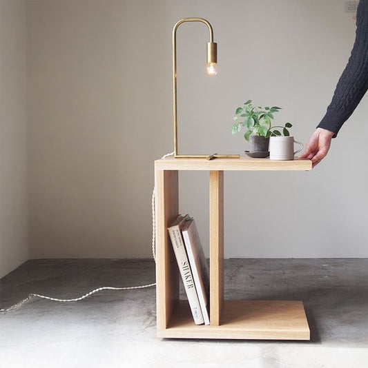 A Good Life solid pinewood still nightstand with a plant, mug, books, and gold table lamp on top
