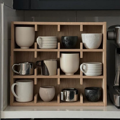 A Good Life minimalist wooden mug rack holding various ceramic and metal mugs in a kitchen setting