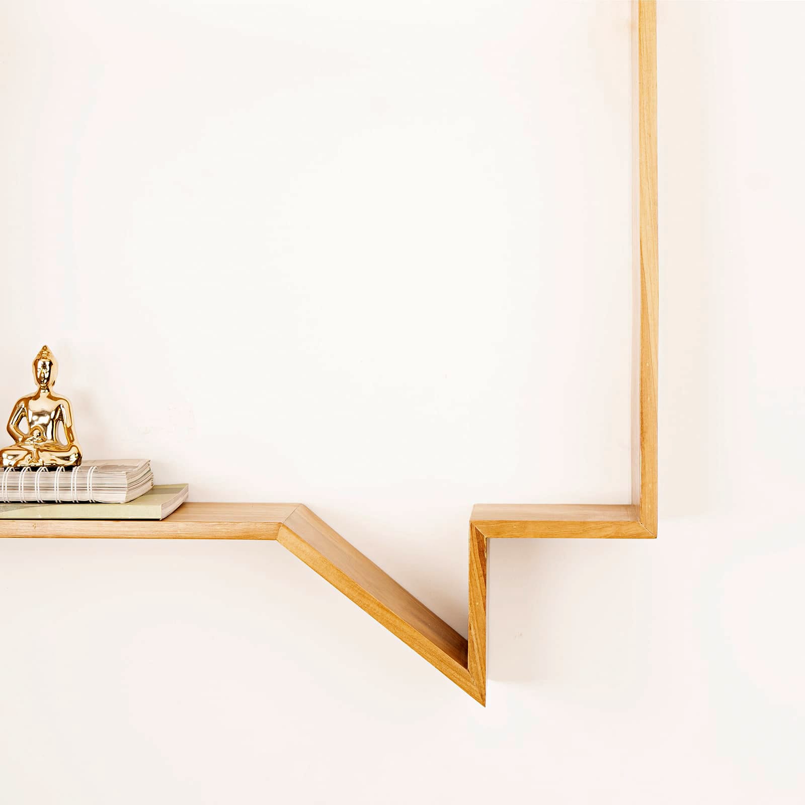 Minimalist Wabi-Sabi quote display shelf by A Good Life with wooden geometric design holding books and a gold statue